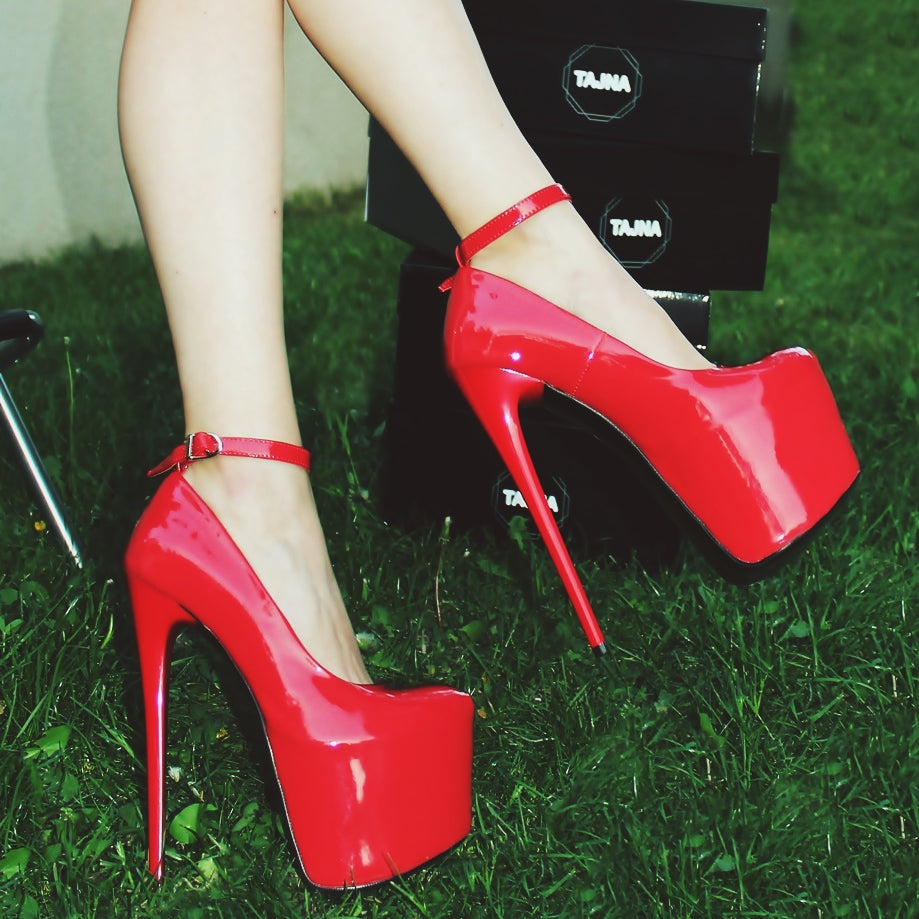 Red patent high heel shoes with ankle strap.