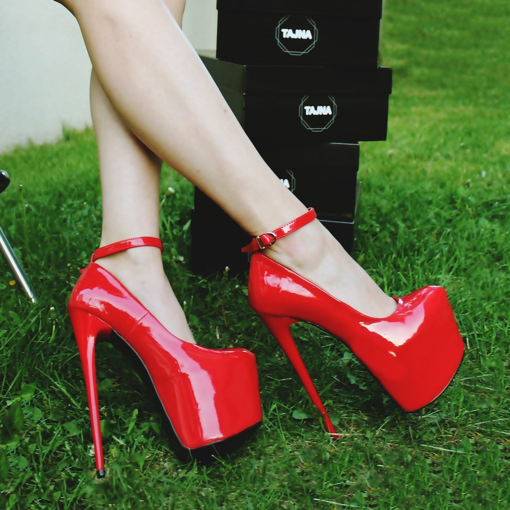 Red patent high heel shoes with ankle strap.